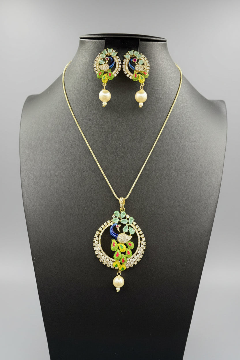 A rhodium-gold plated brass pendant with a peacock design accompanied by earrings, featuring vibrant green, blue, and gold enamel accents, as well as white and turquoise AD stones sparkling embellishments. Party wear set.