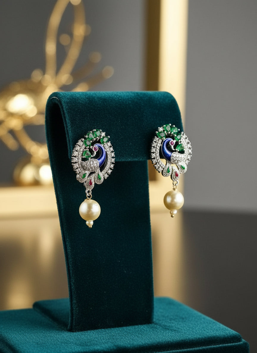 A rhodium-silver plated peacock design accompanied earrings, featuring vibrant green, blue and yellow enamel accents, as well as sparkling white andbottle green AD crystal stones. Earrings design is focused.