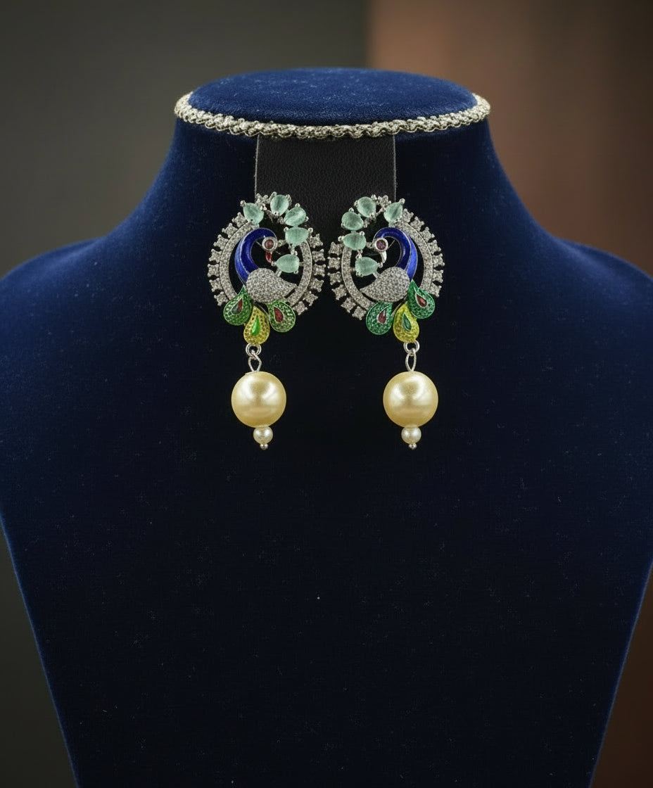 A rhodium-silver plated peacock design accompanied earrings, featuring vibrant green, blue and yellow enamel accents, as well as sparkling white andturquoise crystal stones. Earrings design is focused.