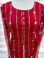 A rose red party wear dress with zari embroidery and pearl embellishments displayed on a mannequin.