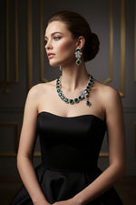 A set of American diamond jewellery consisting of a necklace and earrings with 3D floral elements, featuring bottle green and white stones.