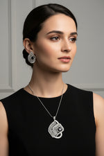 A set of artificial AD pendant and earrings with black centre stone, featuring a geometric design with intricate detailing, displayed on a mannequin.