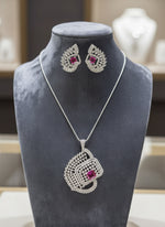 A set of artificial AD pendant and earrings with ruby pink centre stone, featuring a geometric design with intricate detailing, displayed on a mannequin. Party wear set.