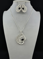 A set of artificial AD pendants with Black centre stone in the pendant and in earrings, featuring a geometric design with intricate detailing, displayed on a mannequin. Party wear set.