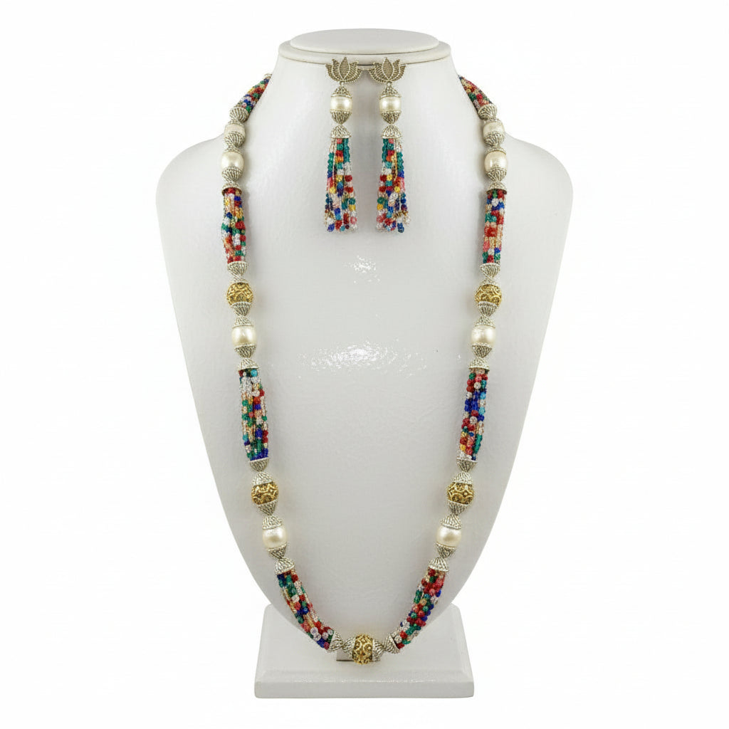 A set of jewellery featuring a long necklace with multi-coloured glass beads and metallic accents, paired with matching earrings, displayed on a mannequin bust. Party wear set.