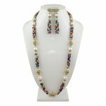 A set of jewellery featuring a long necklace with multi-coloured glass beads and metallic accents, paired with matching earrings, displayed on a mannequin bust. Party wear set.