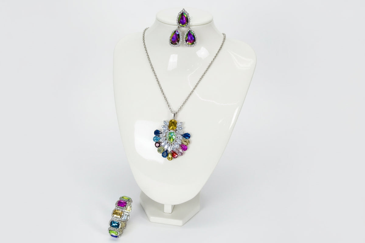 A set of jewellery featuring a multi-coloured gemstone pendant necklace, matching earrings, and a bracelet, displayed on a black mannequin bust. Party wear set.