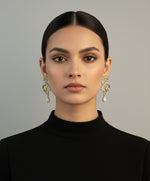 A set of peacock-shaped earrings. The earrings are detailed with green, blue, and gold enamel and has sparkling crystal embellishments. Earrings are focused.