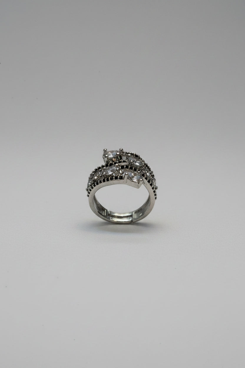 A silver-toned ring with dark, textured detailing sits on a digital scale displaying 5 grams.