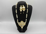 A traditional bridal kundan necklace set displayed on a mannequin, featuring black and gold colours with intricate detailing and pearl beads.