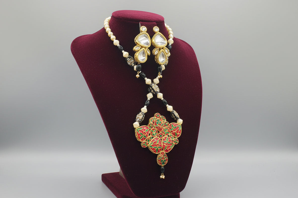 A traditional bridal necklace set displayed on a mannequin, featuring black and gold colours with intricate detailing and pearl beads. Party wear set.