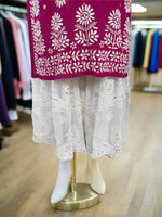 A traditional white gharara with chikankari embroidery displayed on a mannequin. The gharara has a flared design and features golden work on the flare and a knee-round band.