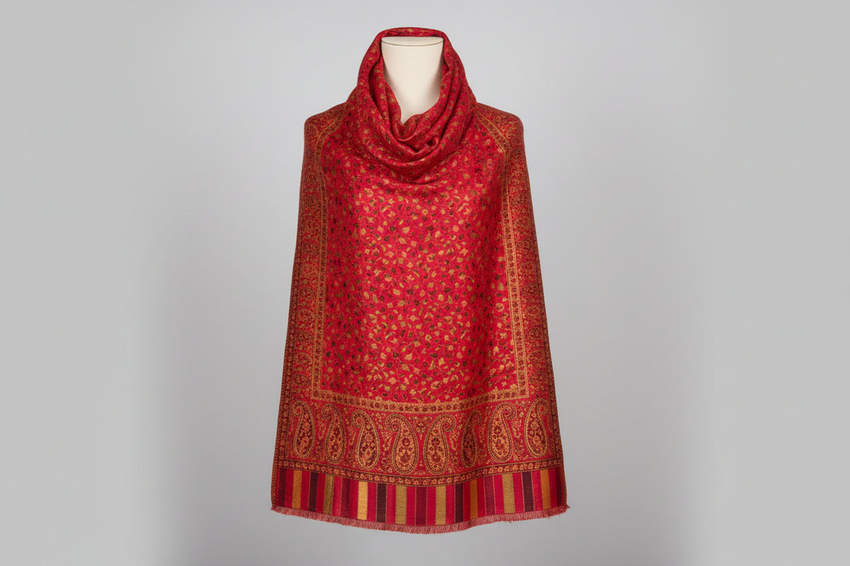 A vibrant Kashmiri party wear red base colour Kani scarf with a floral paisley pattern and border stripes in a red and multicolour design.