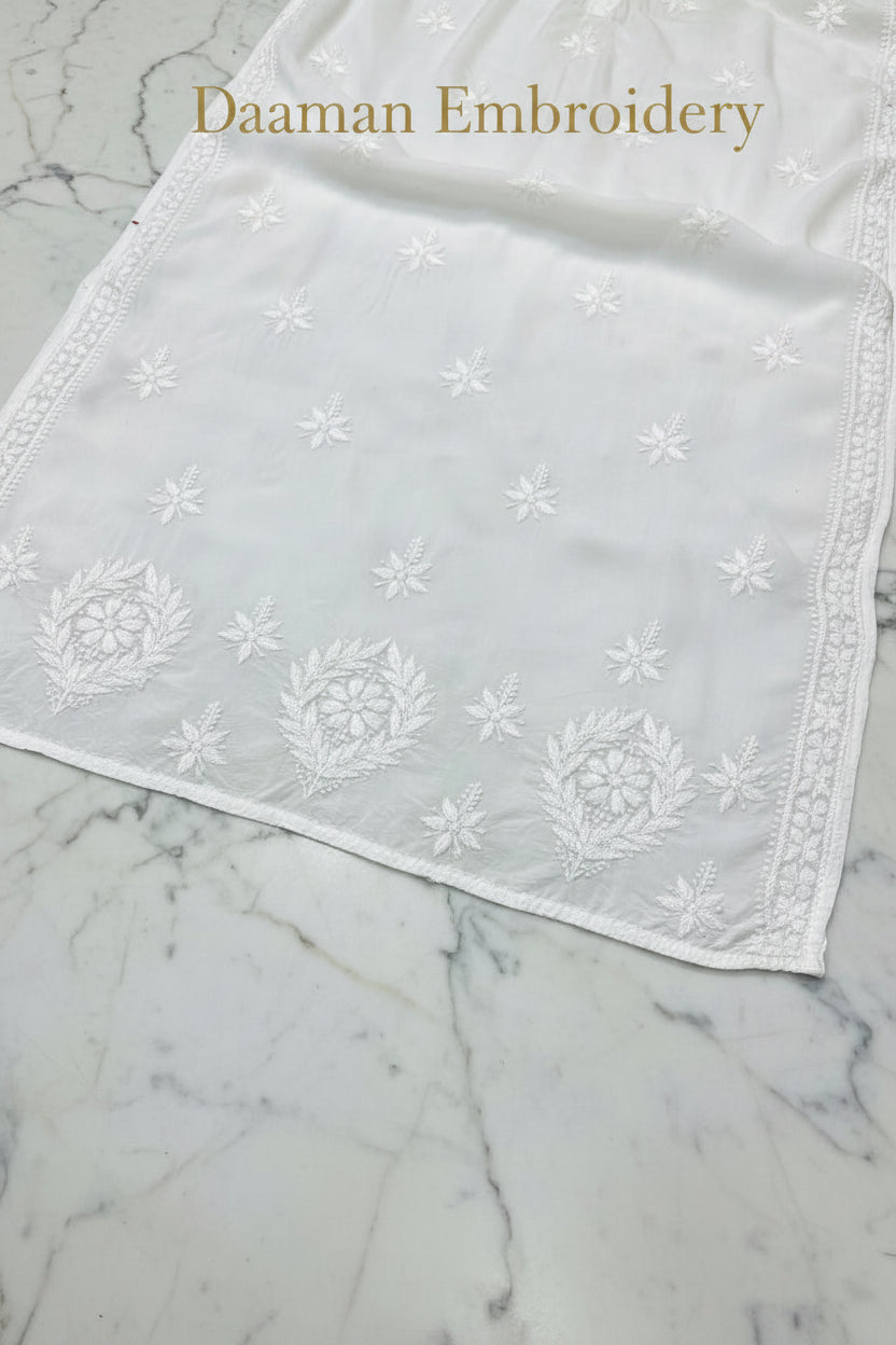 A white modal fabric dense Ghasspati embroidered the lower front border of the Kurti.