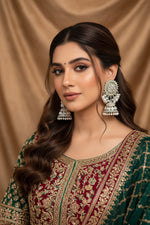 A woman styling posh pearl earrings with a silver-polished brass finish, paired with an elegant silk gown for evening jewellery inspiration.