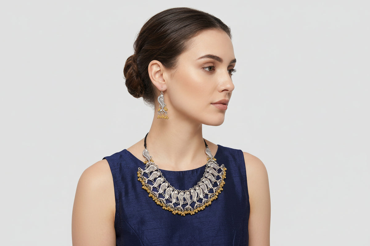 A woman wearing a silver-toned statement necklace with gold-toned beaded accents and matching dangling earrings, shown against a light grey background with measurement callouts and text indicating product dimensions and weight.
