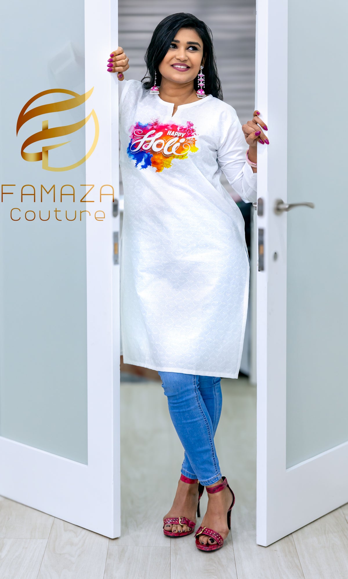 A woman wearing a white cotton kurti with Schiffli Chikankari embroidery, celebrating Holi with colourful powder in the air around her