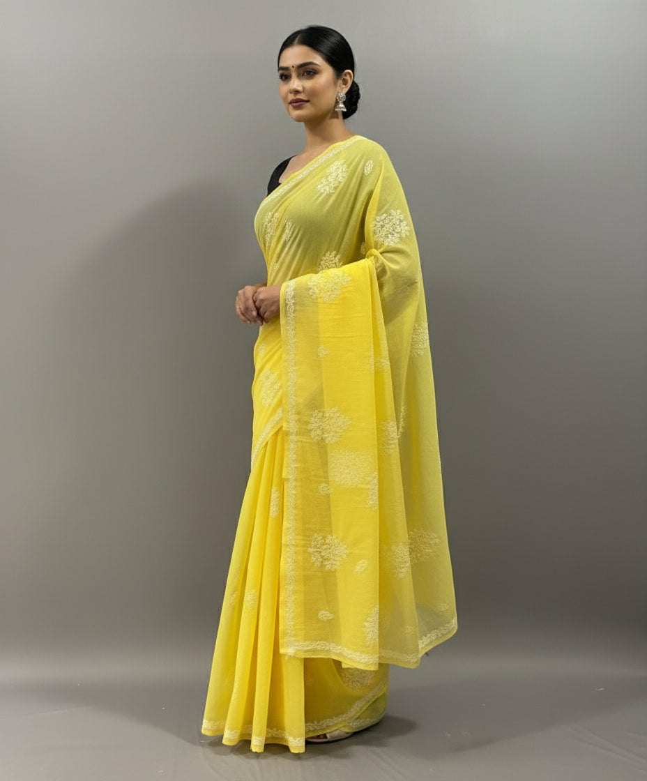A yellow cotton saree with floral embroidery and a blouse piece, draped over on a dummy by famaza couture