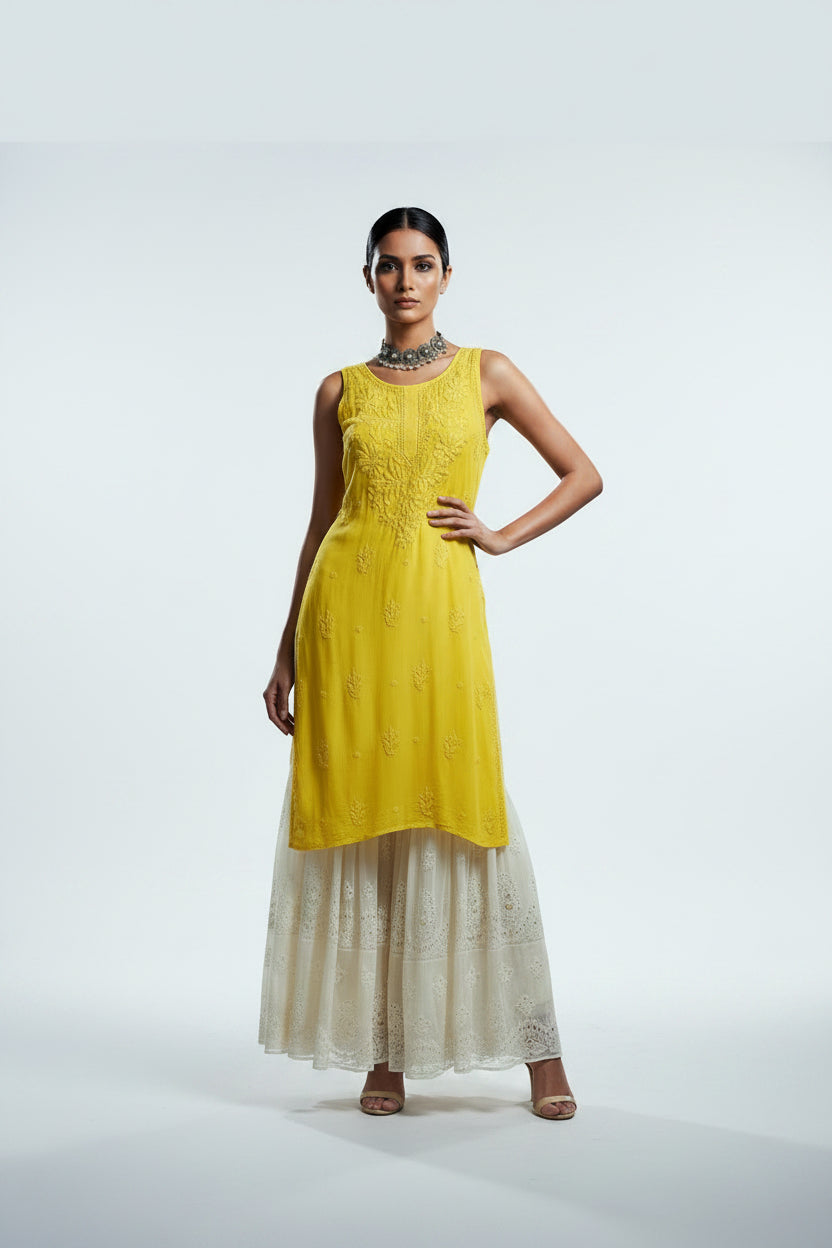 A yellow sleeveless dress displayed on a white mannequin inside a store. The dress has a textured bodice and a layered, ruffled skirt in a light cream or off-white colour.