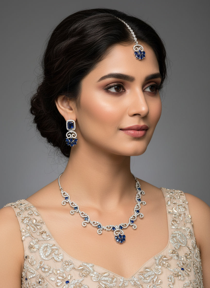 American diamond stones with blue saffire stone in the centre on this jewellery set includes necklace, earrings and maang tikka by famaza couture
