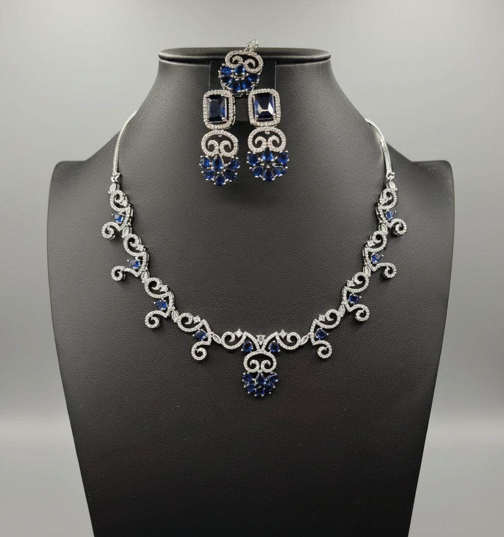 American diamond white stones with blue saffaire stone in the centre on this jewellery set includes necklace, earrings and maang tikka by famaza couture