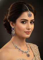 American diamond white stones with purple stone in the centre on this jewellery set includes necklace, earrings and maang tikka by famaza couture