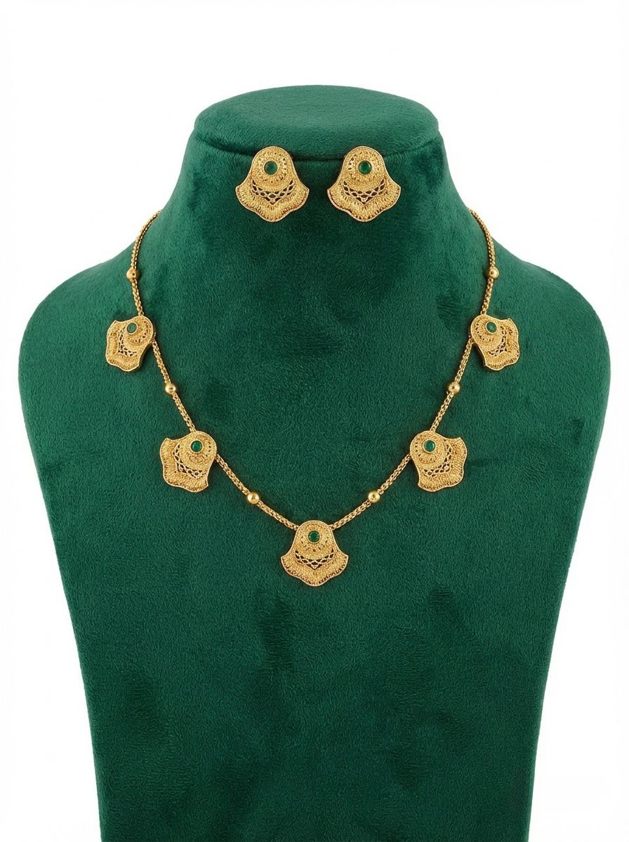 Antique gold brass metal necklace and stud earrings with emerald green central stones.