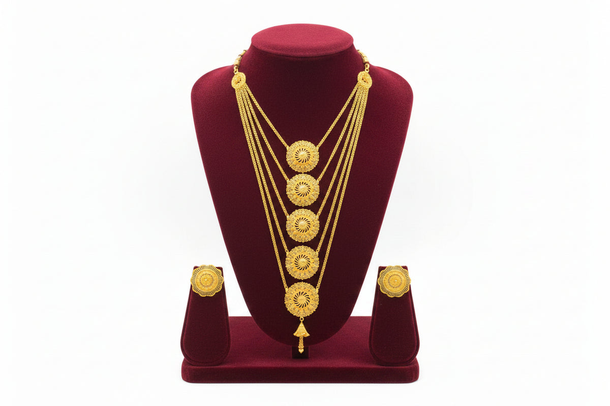 A studio shot of the Ayesha Elite gold-plated multi-layered necklace and matching stud earrings displayed on a black velvet jewelry stand against a white background by Famaza Couture.