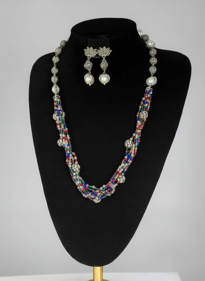 Beaded mala with silver and pearl beads in on both sides start and drop is designed with multi colour glass nano bead and silver ball beads, along withLotus design earrings with silver and pearl beads in drop. Oxidisedjewellery set.
