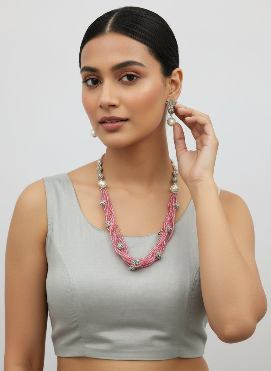 Beaded mala with silver and pearl beads in on both sides start and drop is designed with pink glass nano bead and silver ball beads, along withLotus design earrings with silver and pearl beads in drop. Oxidised party wear jewellery set.