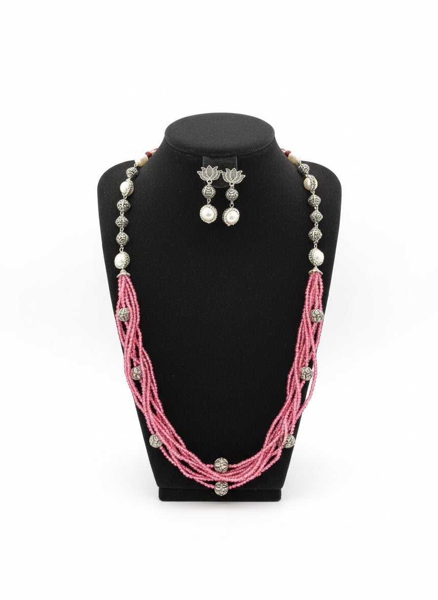 Beaded mala with silver and pearl beads in on both sides start and drop is designed with pink nano glass bead with silver ball beads, along withLotus design earrings with silver and pearl beads in drop. Oxidised party wear jewellery set.