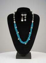 Beaded mala with silver and pearl beads in on both sides start and drop is designed with sky blue colour glass nano bead and silver ball beads, along withLotus design earrings with silver and pearl beads in drop. Oxidised party wear jewellery set.