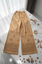 Beige embroidered fabric on a white marble surface