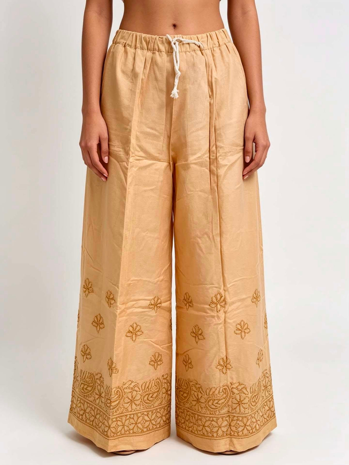 Beige pants with floral embroidery on a white background