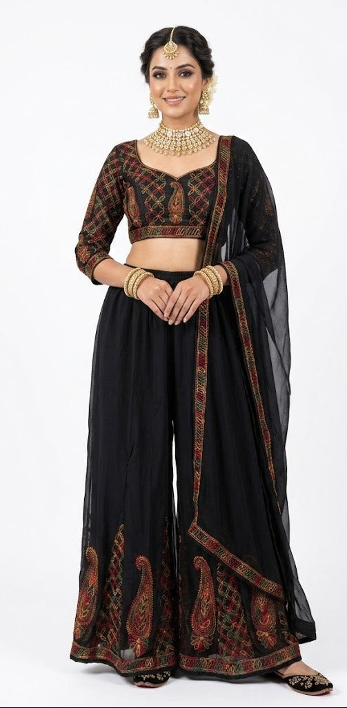 Front view of a model wearing a black georgette wide-leg sharara with intricate multi-color paisley thread embroidery at the hem, styled with a blouse (blouse not included.