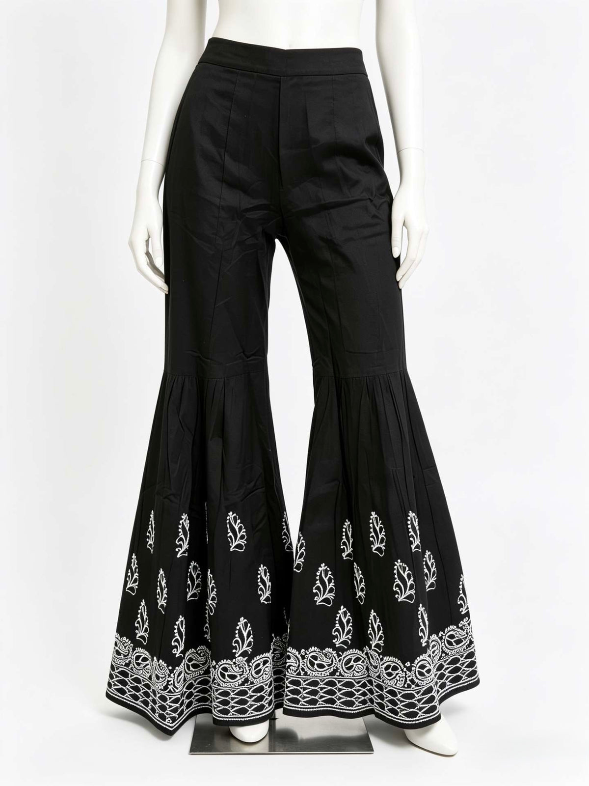 Black bell-bottom pants with white lace trim on a mannequin against a white background