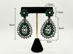 Black brass teardrop earrings featuring a rich green stone floral stud and matching green stone accents on the intricate filigree teardrop design.