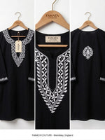 Black cotton tunic top with white embroidered patterns, shown from front and back on wooden hangers against a white background. The brand name FAMAZA COUTURE is visible on the hangers and hangtag.