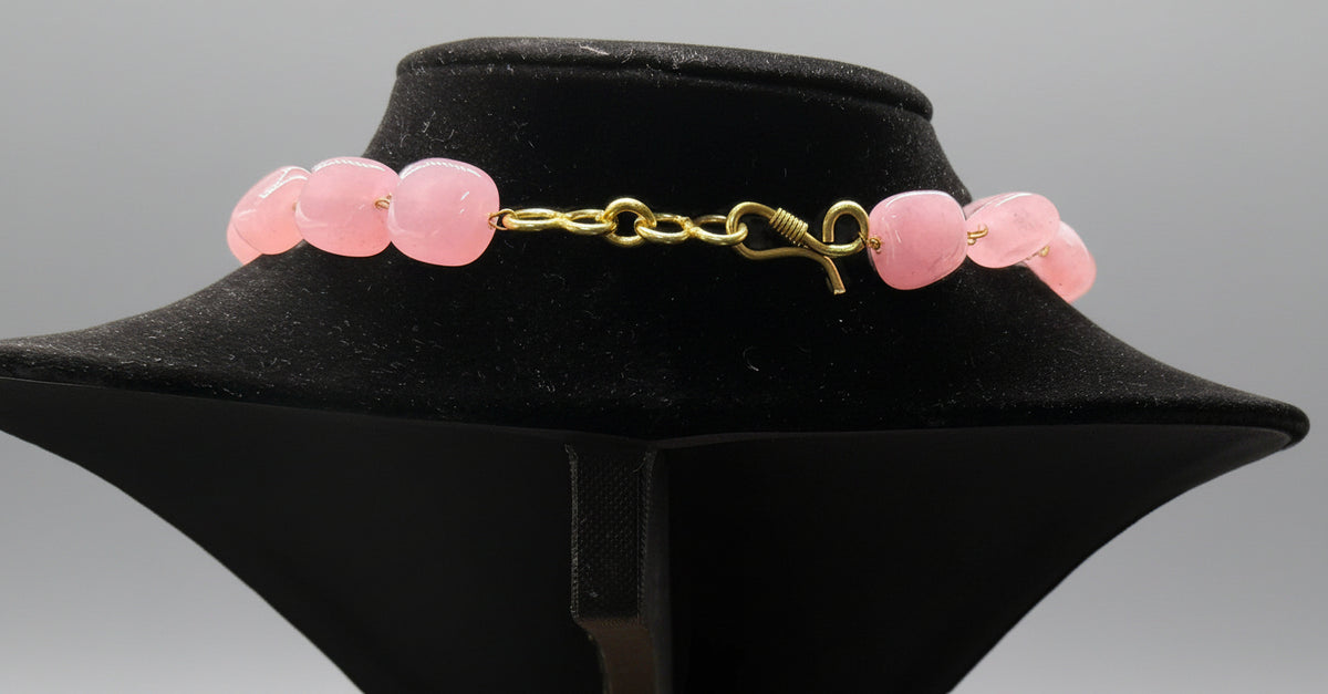 A black mannequin showcasing a Bollywood style Mona Lisa stone and crystal beaded Mala set, with pink colour of beads and gold-tone accents. Party wear jewellery set.