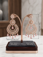 A pair of luxury rose gold chaand bali chandelier earrings on a jewelry display stand, featuring clear marquise American Diamonds in a floral sunburst design with hanging blush pink teardrop gemstones.