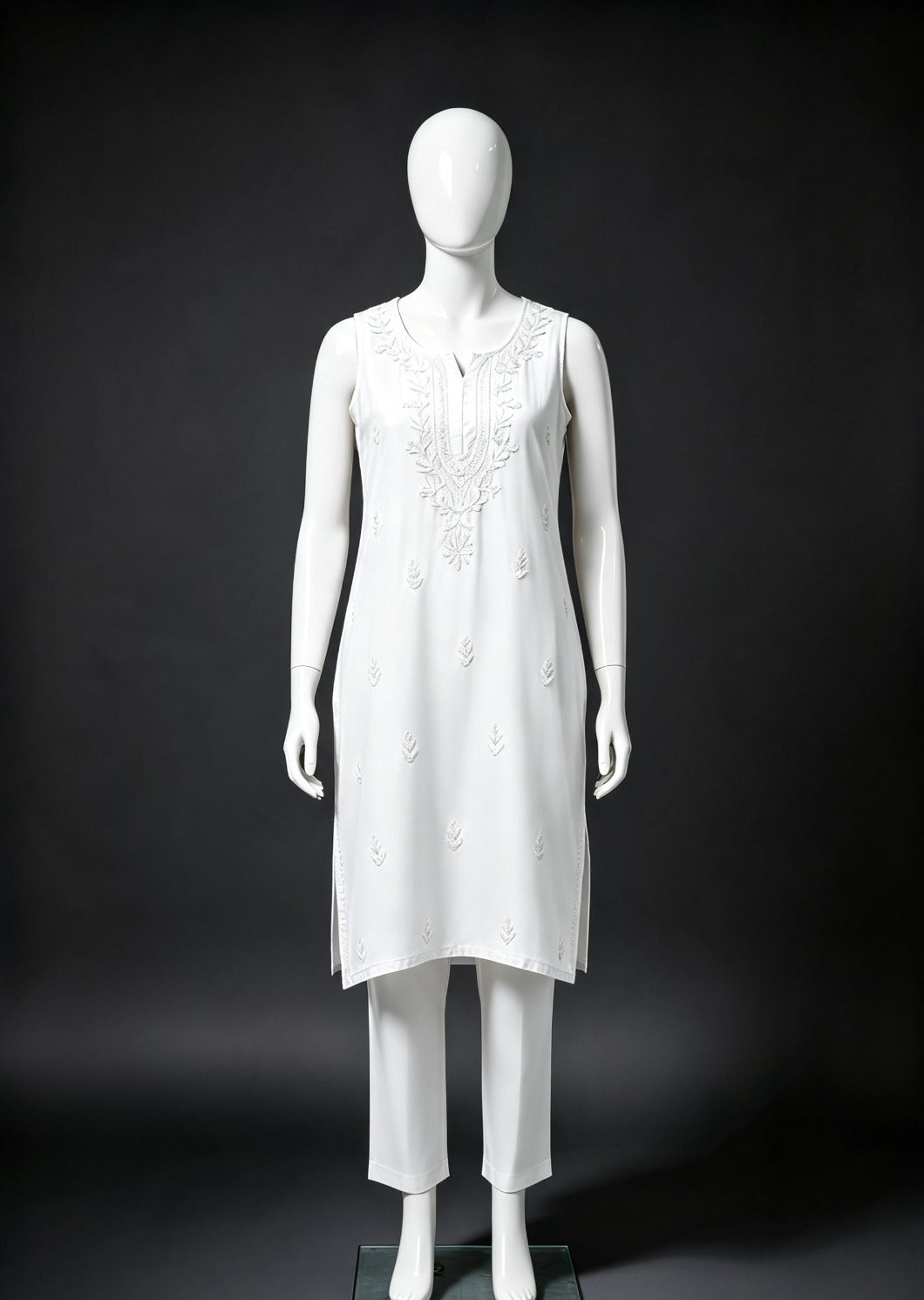 Full-length front view of the white handcrafted sleeveless Chanderi silk Chikankari co-ord set displayed on a white mannequin against a dark contrasting background.
