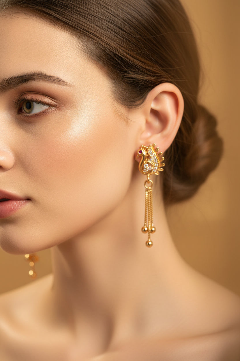 Close-up of 4cm rose gold finish earrings featuring a peacock motif with white stones and a ruby-red eye.
