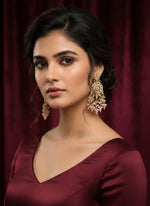 Close-up of a fashion model wearing English style rose gold plated brass earrings, demonstrating the perfect evening jewellery for gala events and luxury party wear.