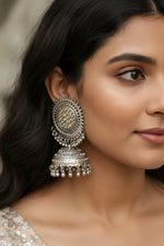 Close-up of a girl wearing premium silver oxidised jhumka earrings, a perfect alternative to golden earrings for bridal jewellery and wedding guest styling.