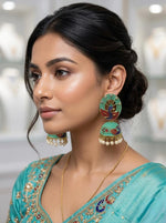 Close-up of a model wearing 5.5cm turquoise peacock earrings with cascading white pearl accents.