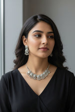 Close-up of a woman wearing a heavy oxidised mirror-work choker with matching mandala earrings, showcasing the tribal silver aesthetic.