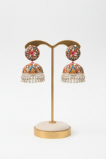Pair of floral earrings on a gold earring stand with a white background