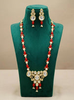 Close-up of the intricate central Kundan pendant, highlighting the large stone work, red bead drops, and fine golden finish.