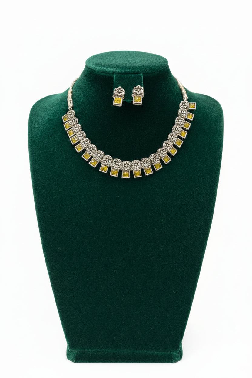 Close-up of the square-cut yellow gemstone and the intricate floral metalwork of the oxidised silver collar.