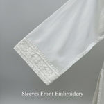 Close-up of white embroidered sleeves front pattern for boutique website page.